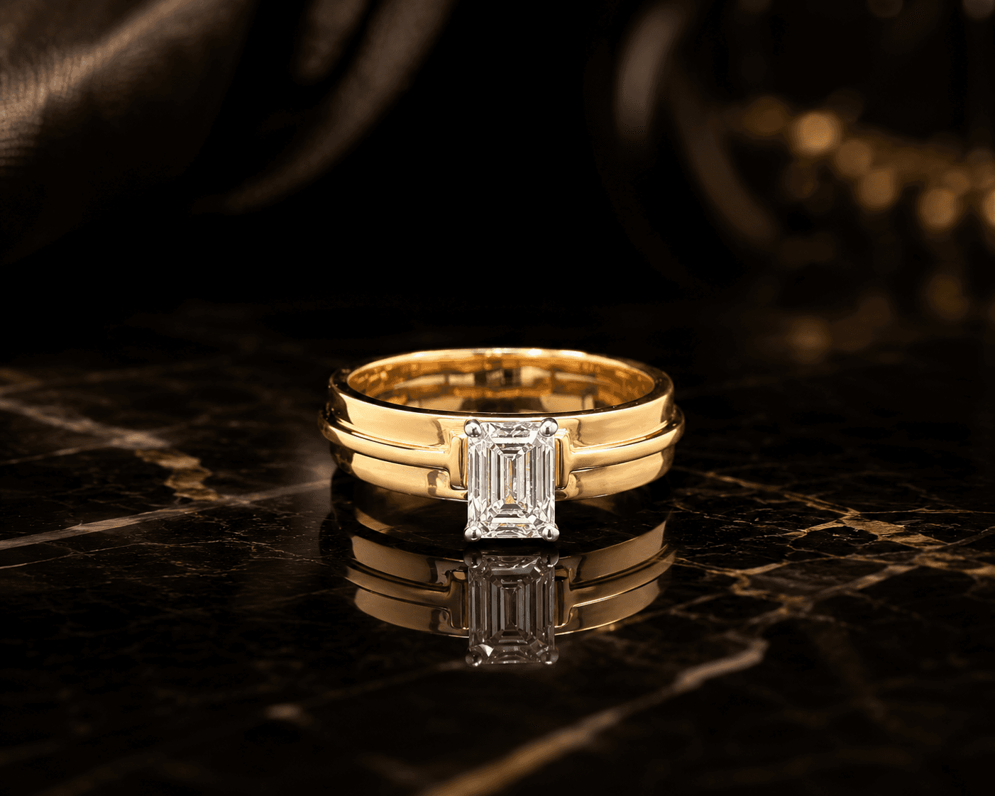 A single emerald-cut diamond set low into a broad polished gold band.